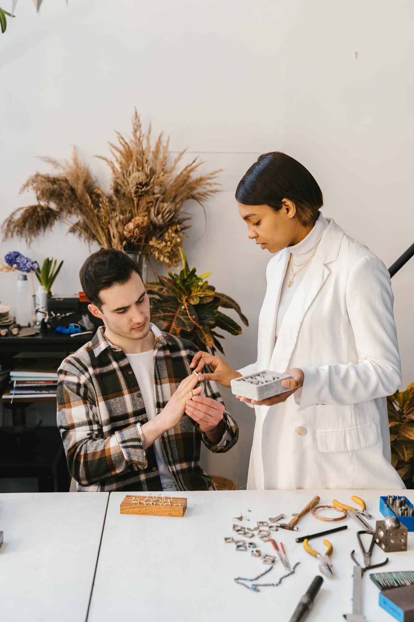 Two adults collaborating in a creative workspace with tools and plants.